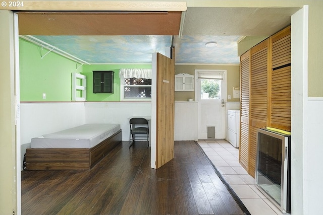 bathroom featuring washer / clothes dryer, wood-type flooring, ornamental molding, beverage cooler, and electric panel