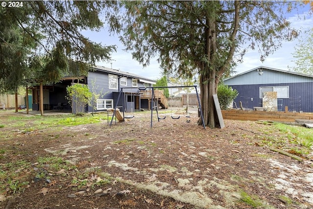 7825 SE Bybee Blvd, Portland, OR 97206 - view of yard featuring a wooden deck, stairs, and a playground