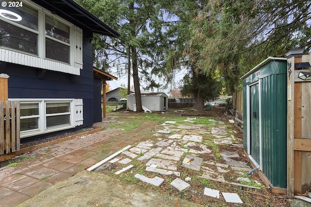 view of yard featuring a patio and a storage shed