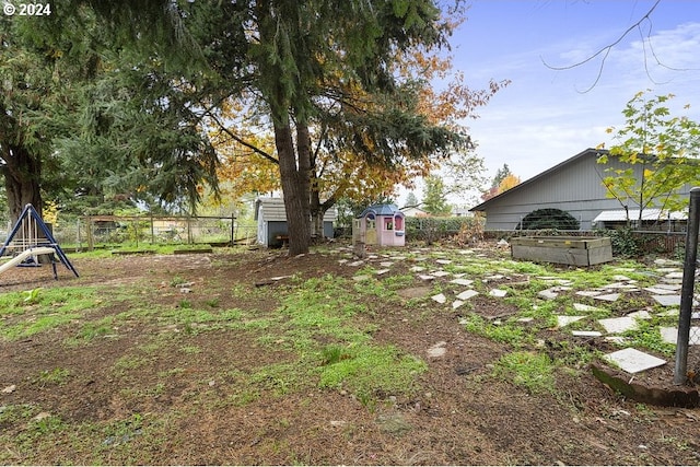 view of yard with an outbuilding, fence, and a storage shed