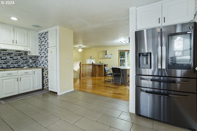 kitchen featuring decorative backsplash, light hardwood / wood-style flooring, stainless steel fridge with ice dispenser, white cabinetry, and ceiling fan