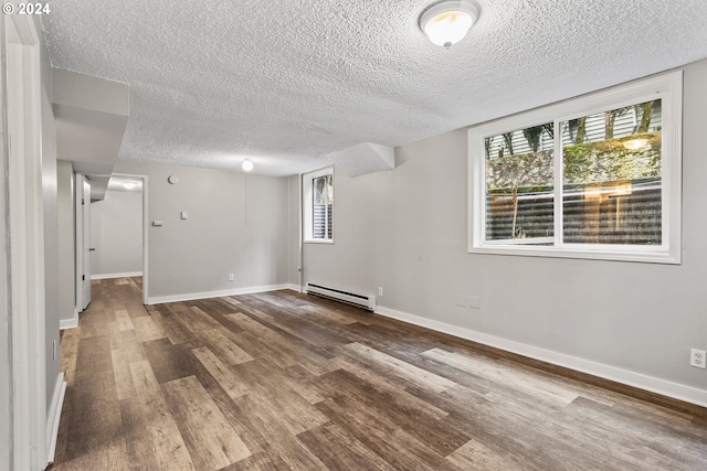 unfurnished room with a textured ceiling, a baseboard radiator, and wood-type flooring