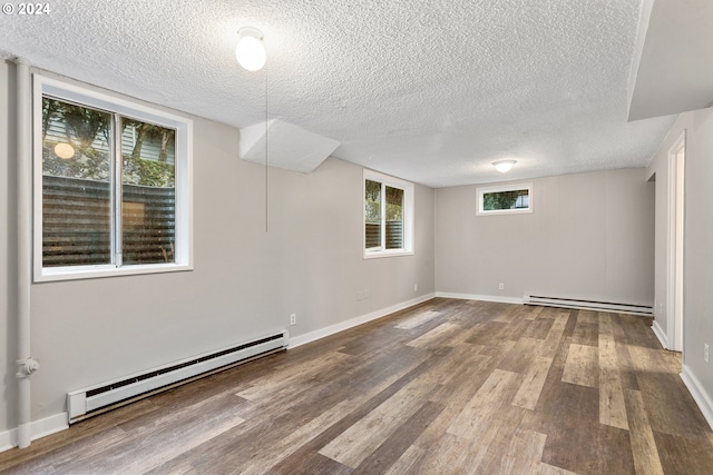 unfurnished room with a baseboard radiator, hardwood / wood-style floors, and a textured ceiling