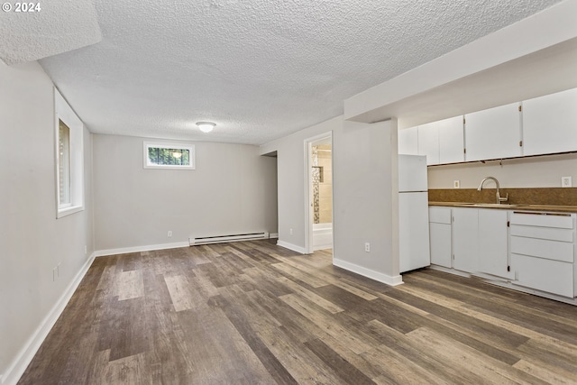 kitchen with a textured ceiling, baseboard heating, wood-type flooring, and white refrigerator