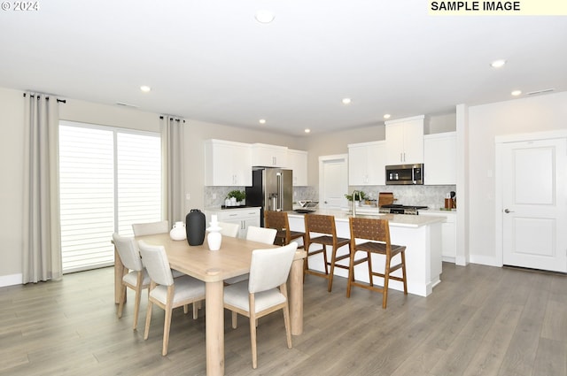 dining room with light hardwood / wood-style floors and sink