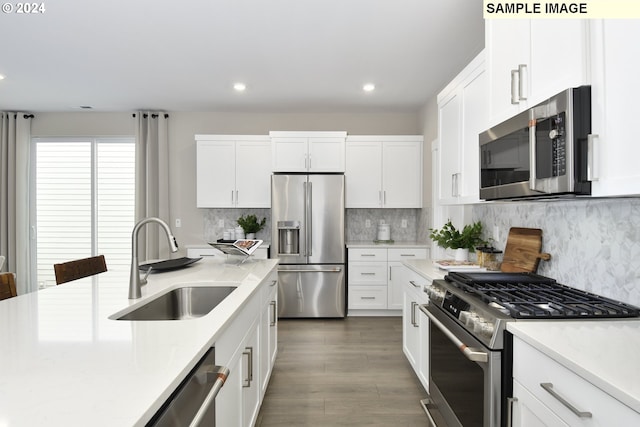 kitchen featuring decorative backsplash, appliances with stainless steel finishes, dark hardwood / wood-style flooring, sink, and white cabinetry