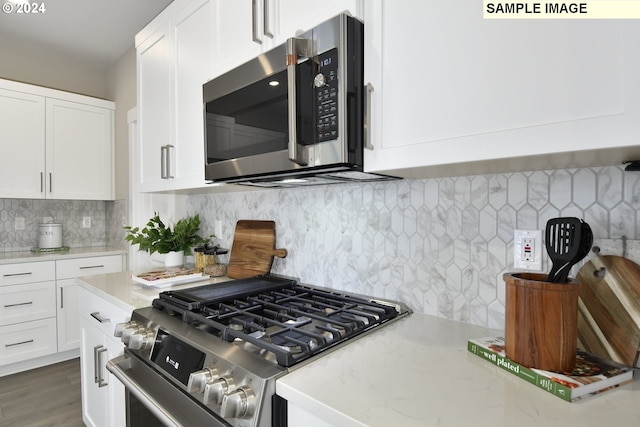 kitchen featuring light stone countertops, dark hardwood / wood-style flooring, backsplash, white cabinets, and appliances with stainless steel finishes