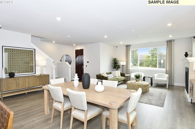 dining space with hardwood / wood-style flooring and a fireplace