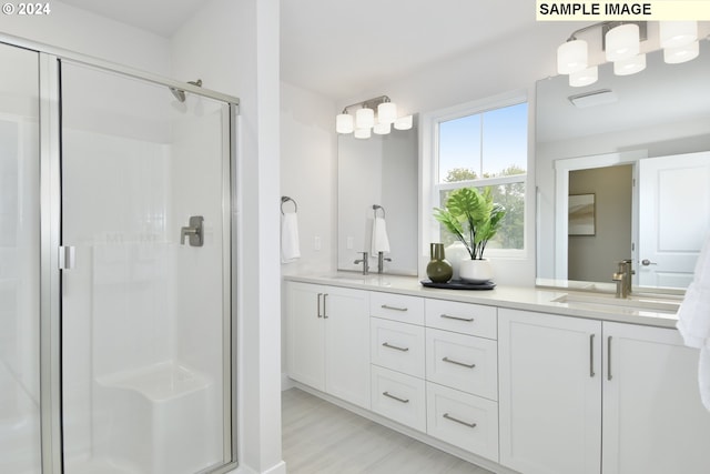 bathroom with hardwood / wood-style floors, vanity, and an enclosed shower