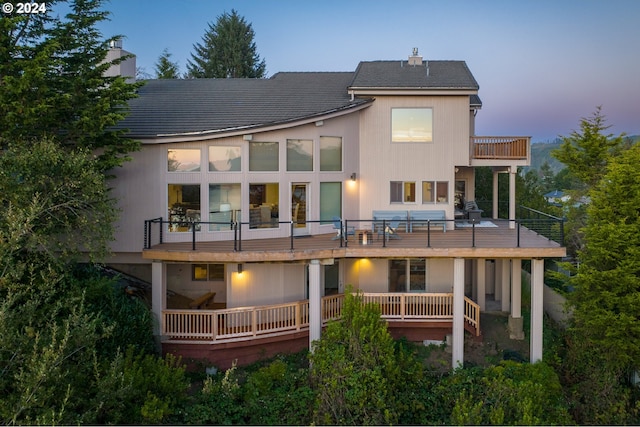 back house at dusk with a balcony