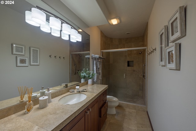 bathroom featuring tile patterned flooring, vanity, a shower with door, and toilet