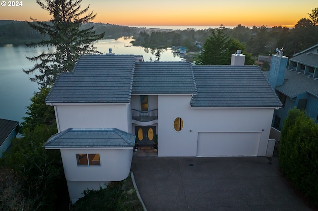 view of front of property featuring a garage and a water view