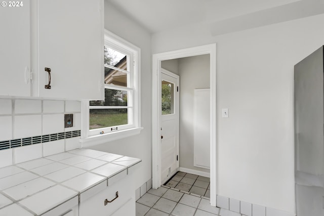 1212 Laurel St Unit 9, Lake Oswego, OR 97034 - kitchen with white cabinets, light tile patterned flooring, tile countertops, and baseboards