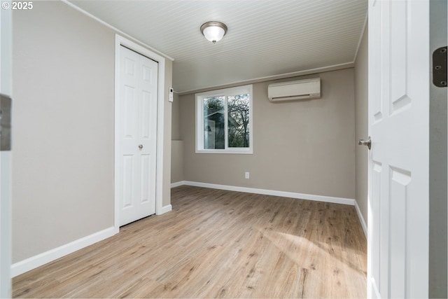 unfurnished bedroom featuring a closet, a wall mounted AC, and light hardwood / wood-style flooring