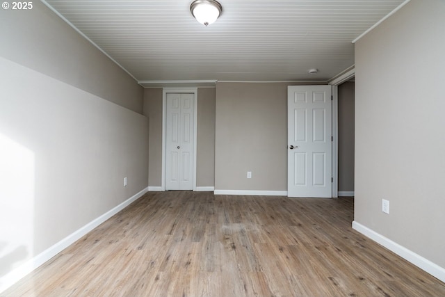 unfurnished bedroom with crown molding, light hardwood / wood-style floors, and a closet