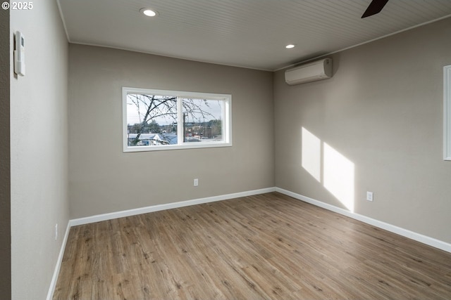 spare room featuring light hardwood / wood-style floors and an AC wall unit