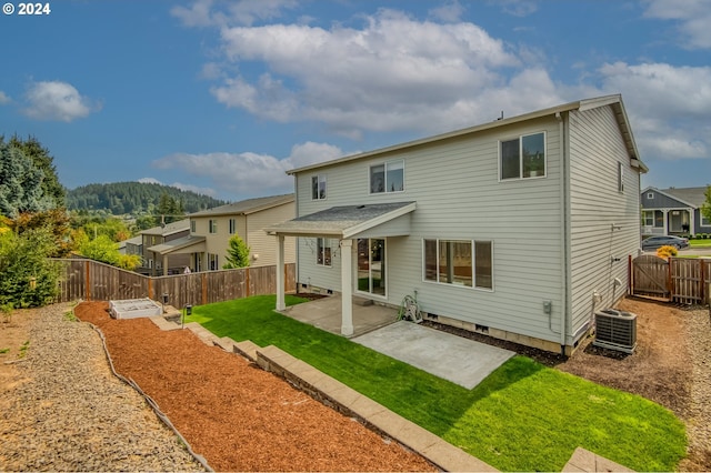 back of property with central AC, a patio, and a yard