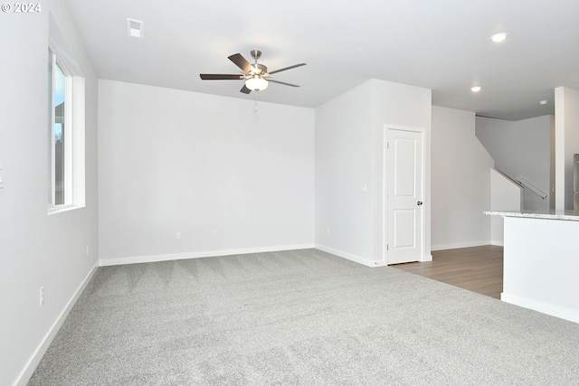 spare room featuring dark carpet and ceiling fan