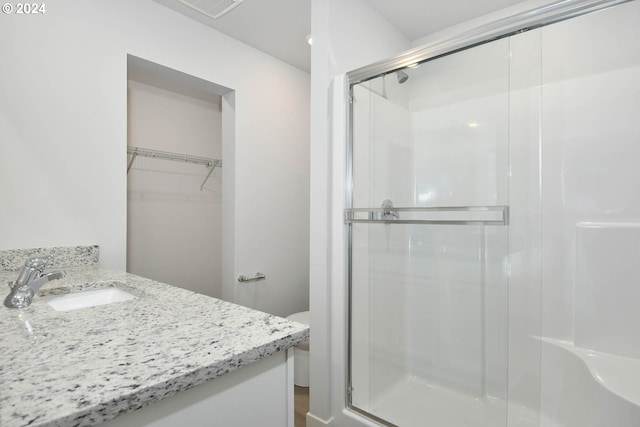 bathroom with vanity, toilet, and walk in shower