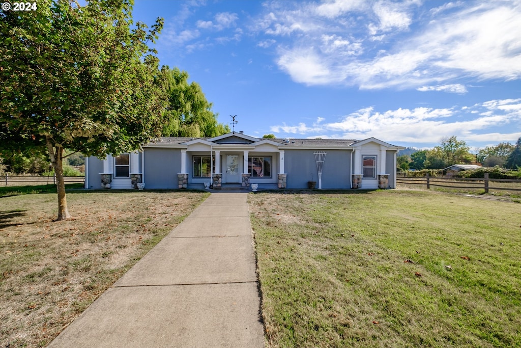 ranch-style house with a front yard and a porch