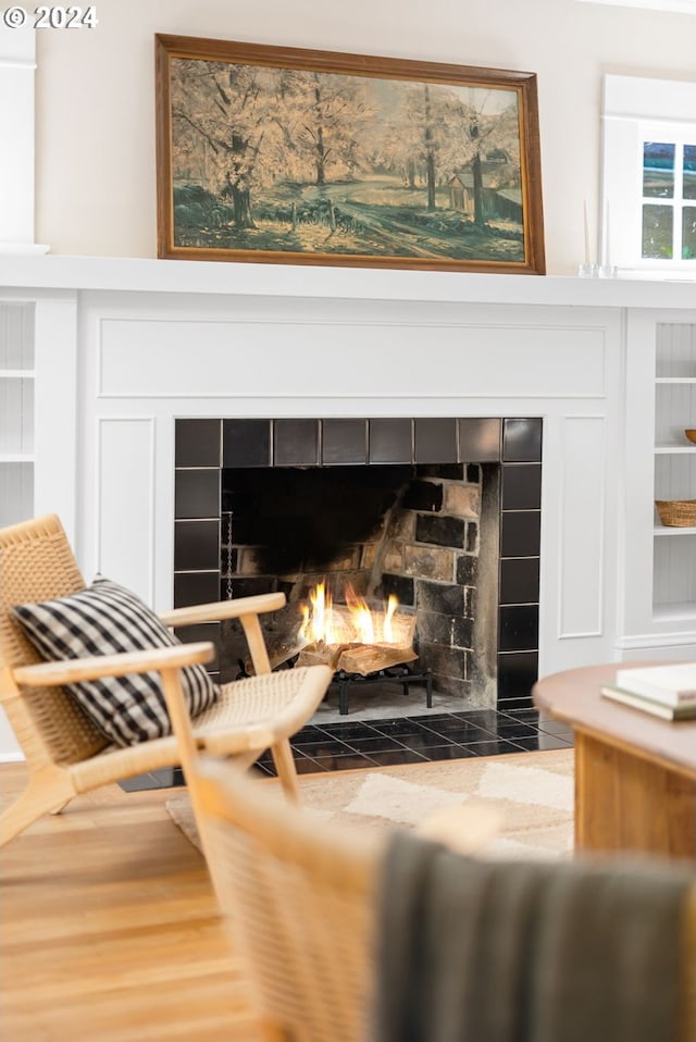 interior details with hardwood / wood-style floors and a tile fireplace