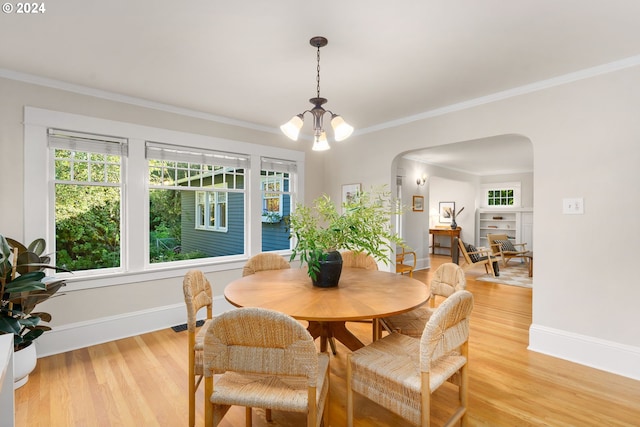 dining room featuring light wood-type flooring, an inviting chandelier, and ornamental molding