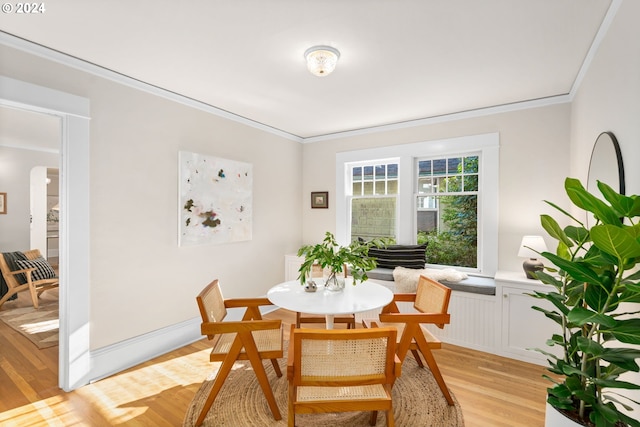 dining space featuring ornamental molding and light hardwood / wood-style floors