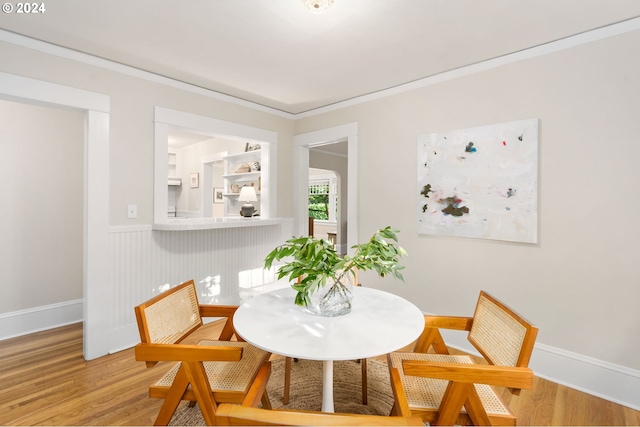 dining space featuring ornamental molding and wood-type flooring