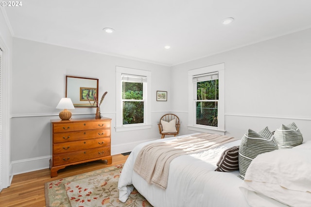 bedroom with ornamental molding and light wood-type flooring