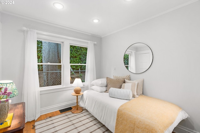 bedroom with hardwood / wood-style flooring and crown molding