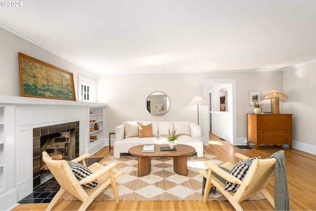 living room featuring a fireplace, ornamental molding, and hardwood / wood-style floors