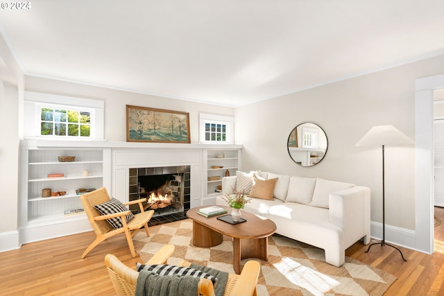 living room with light wood-type flooring and a tile fireplace