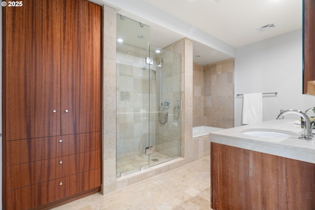 bathroom featuring a stall shower, visible vents, a bath, and vanity