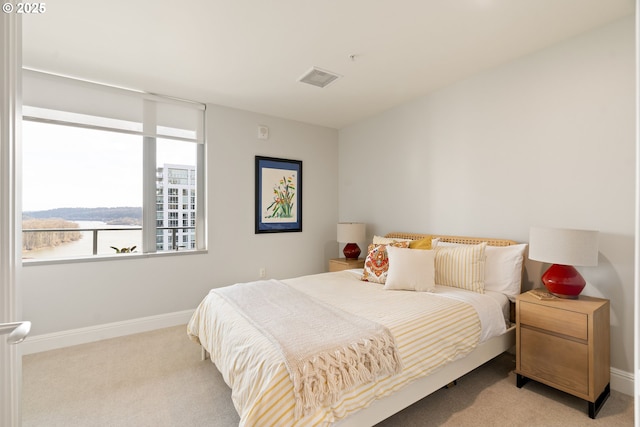 bedroom featuring light carpet and baseboards