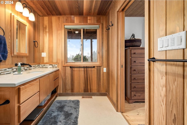 bathroom featuring vanity, wood-type flooring, wooden ceiling, and wooden walls