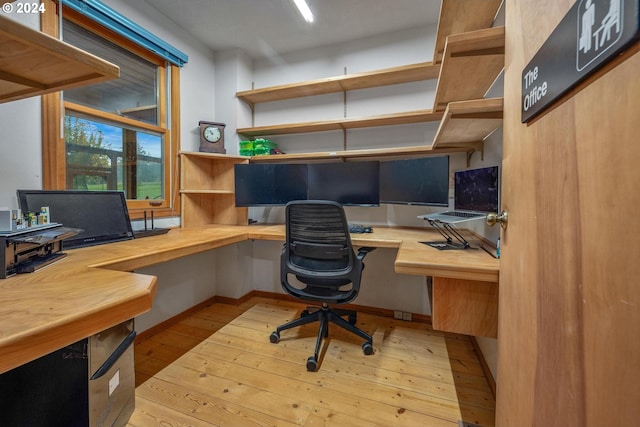 office area with light wood-type flooring and built in desk