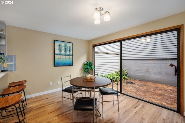 dining area featuring light hardwood / wood-style flooring and a notable chandelier