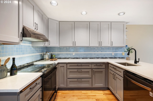 kitchen featuring black dishwasher, electric range, light wood-type flooring, gray cabinets, and sink