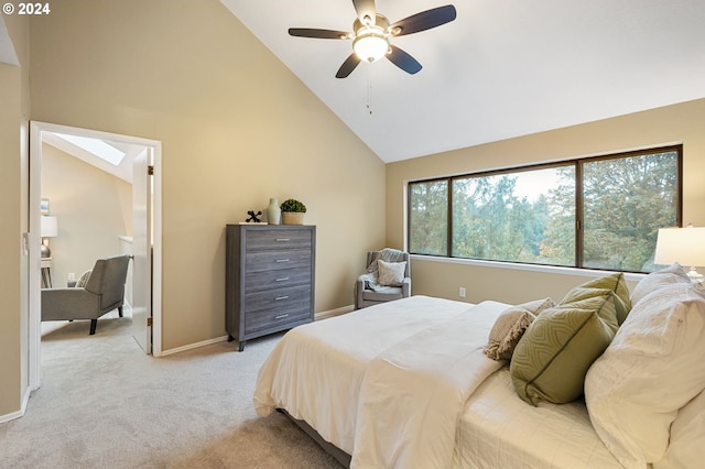 carpeted bedroom featuring a skylight, high vaulted ceiling, and ceiling fan