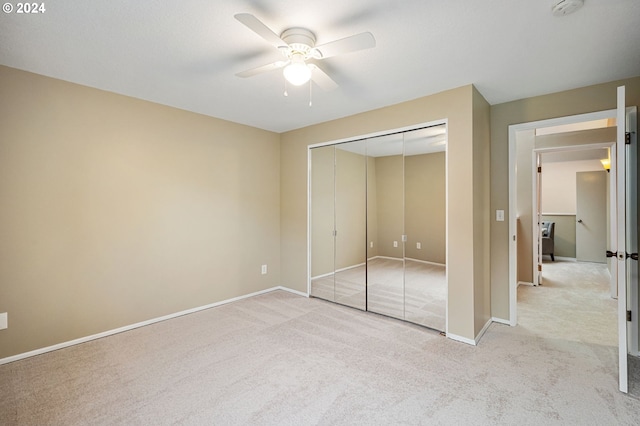 unfurnished bedroom featuring a closet, ceiling fan, and light colored carpet