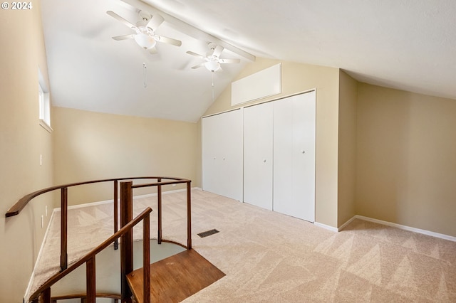 additional living space with ceiling fan, light colored carpet, and vaulted ceiling