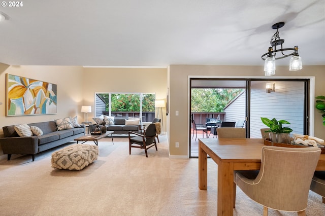 carpeted living room with an inviting chandelier