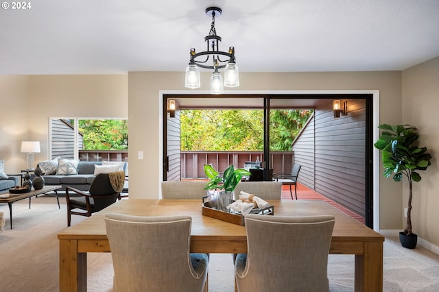 carpeted dining area featuring a chandelier