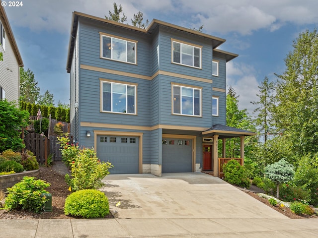 view of front of property featuring a garage, driveway, and fence