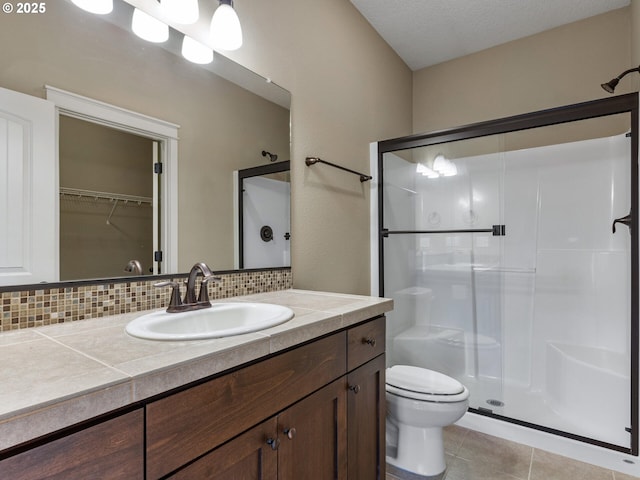 bathroom featuring toilet, a stall shower, decorative backsplash, and tile patterned floors