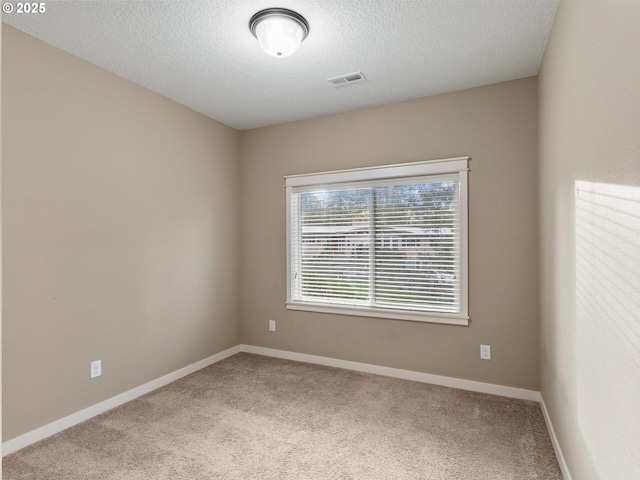 spare room with visible vents, baseboards, carpet flooring, and a textured ceiling