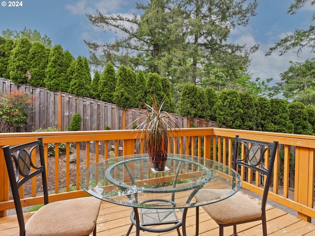deck featuring outdoor dining area and a fenced backyard