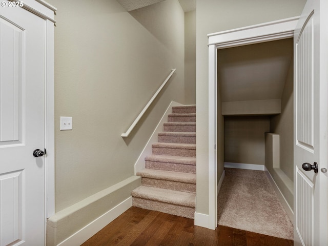 stairway featuring baseboards and wood finished floors
