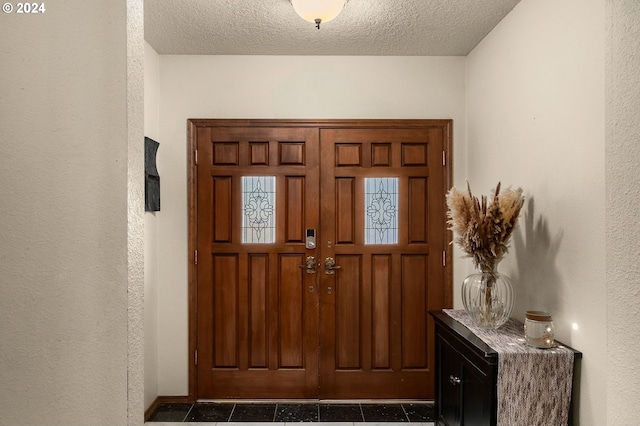 foyer entrance with a textured ceiling