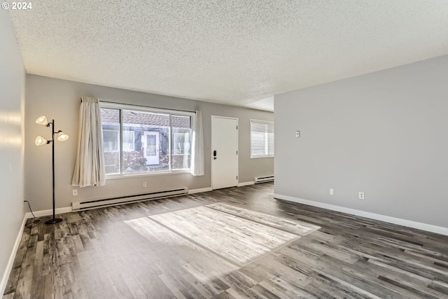 unfurnished room with a baseboard heating unit, wood-type flooring, and a textured ceiling